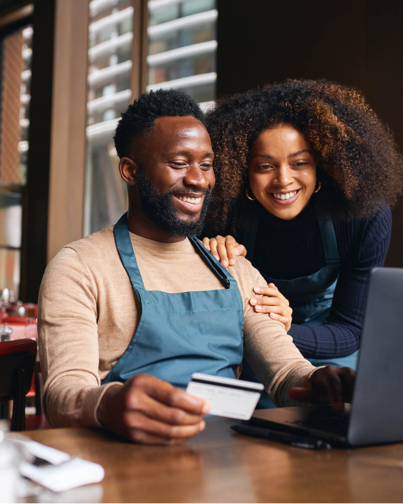 man and woman looking at computer with credit card