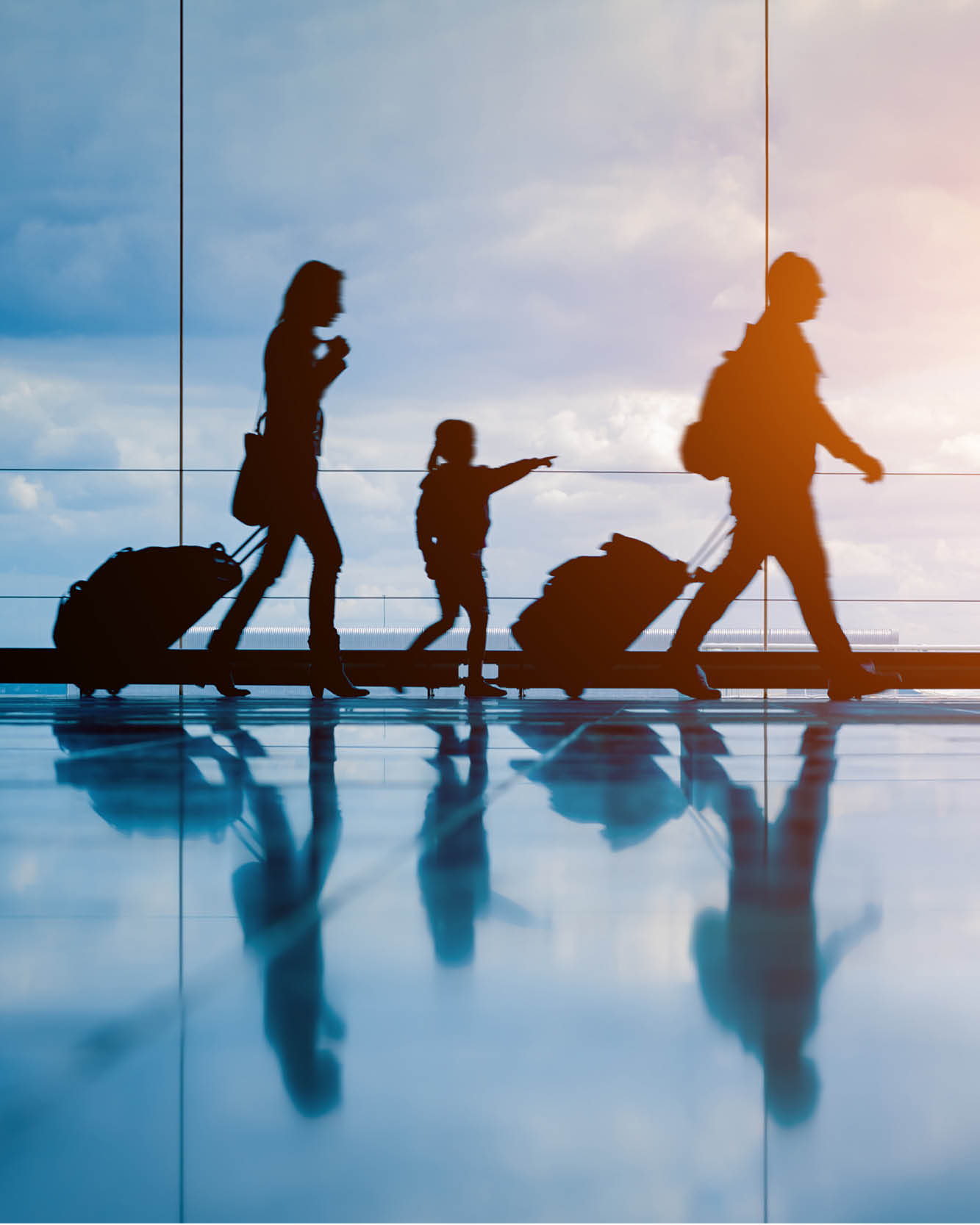 family walking through airport with luggage