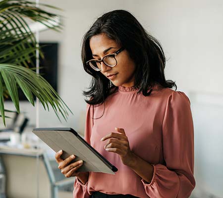 Woman with glasses looking at tablet