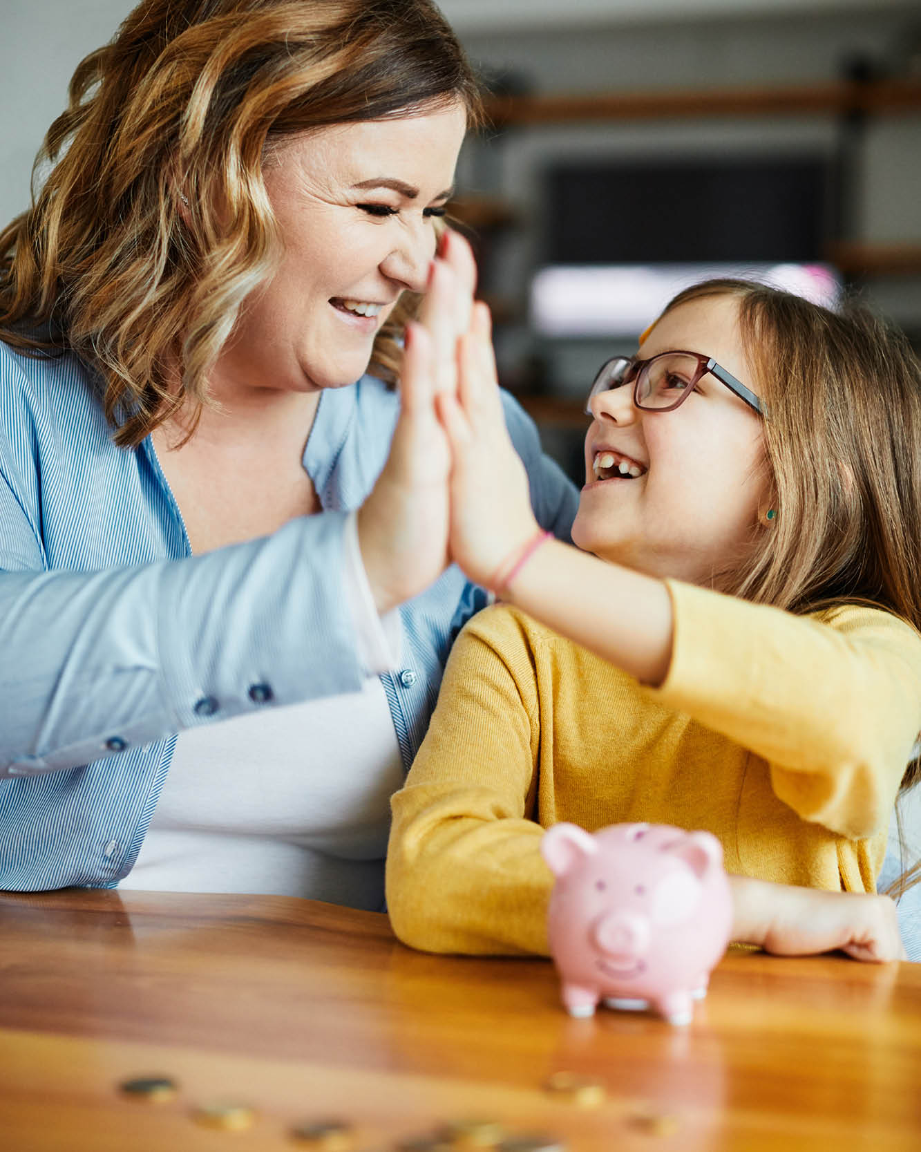 Mom and daughter saving money in piggy bank