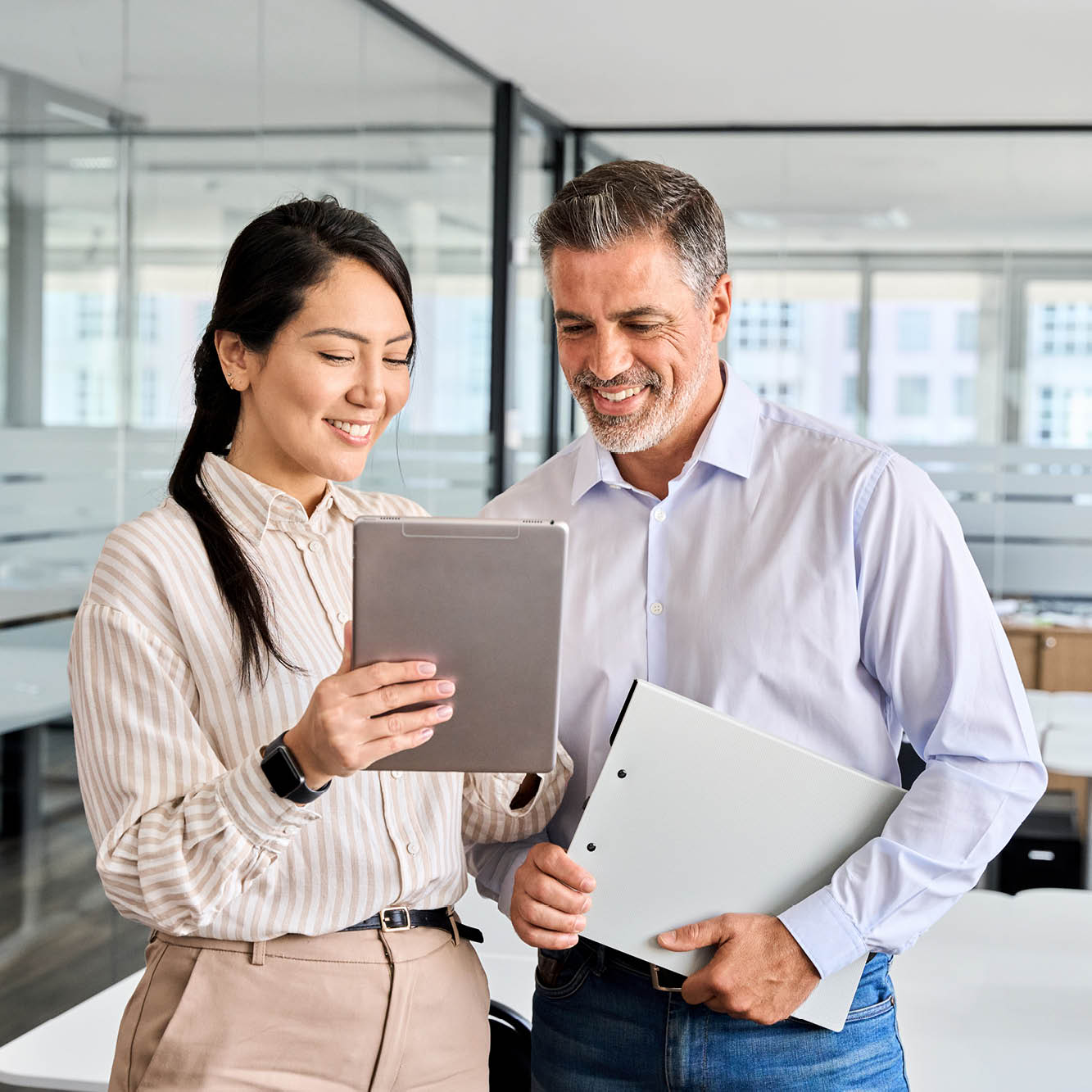 man and woman in office looking at tablet