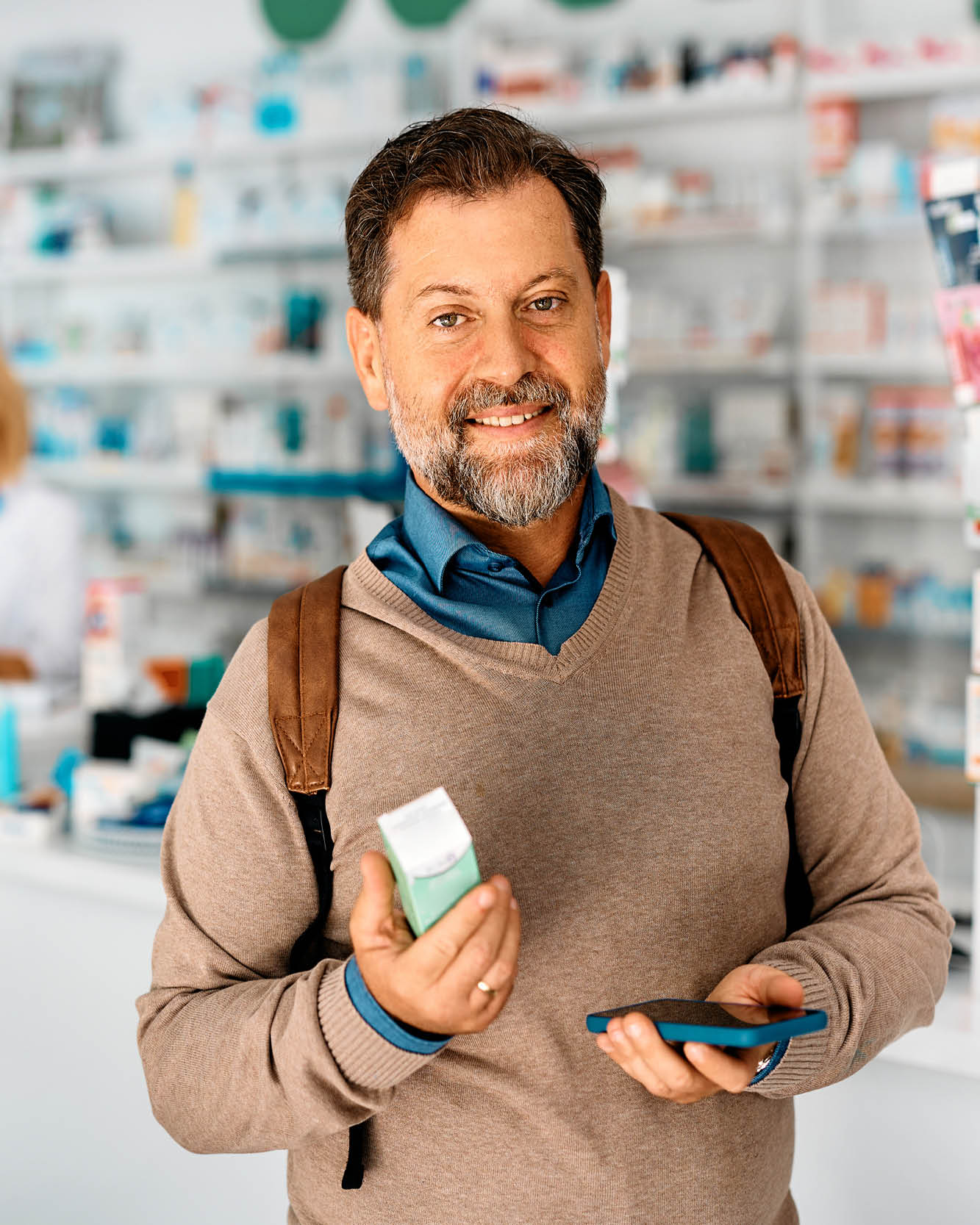 Man shopping in drugstore holding mobile phone