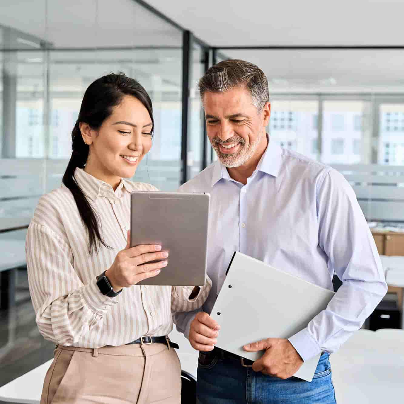 Coworkers in a office look at a document. 