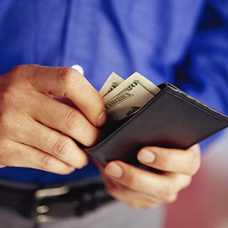 Man pulling two twenty dollar bills out of wallet.