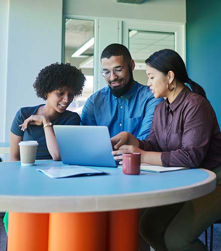 three people looking at laptop