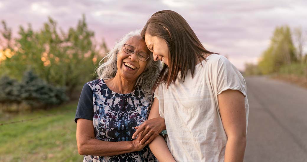 older and younger woman smiling and walking
